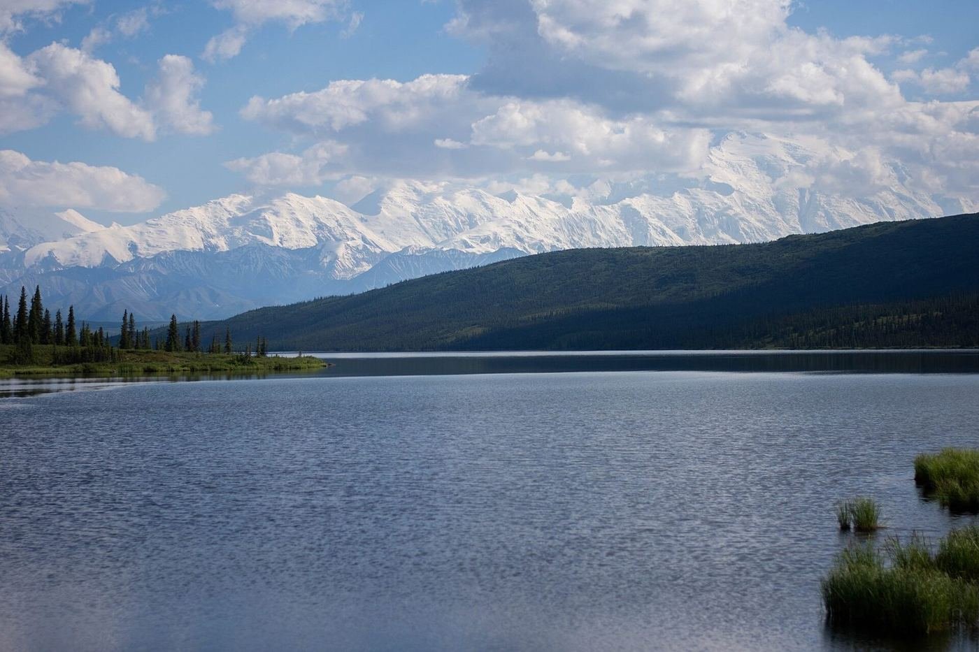 Mount Denali and its neighboring peaks rising above the water of Wonder Lake