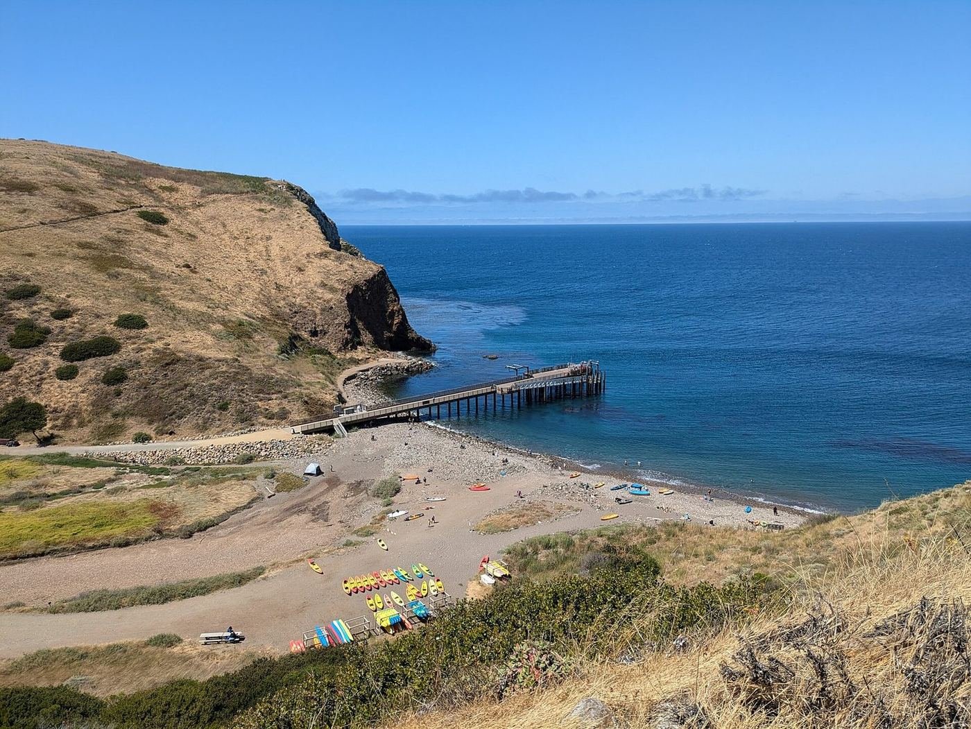 The pier and curved beach at Scorpion Anchorage on Santa Cruz Island with the blue Pacific beyond
