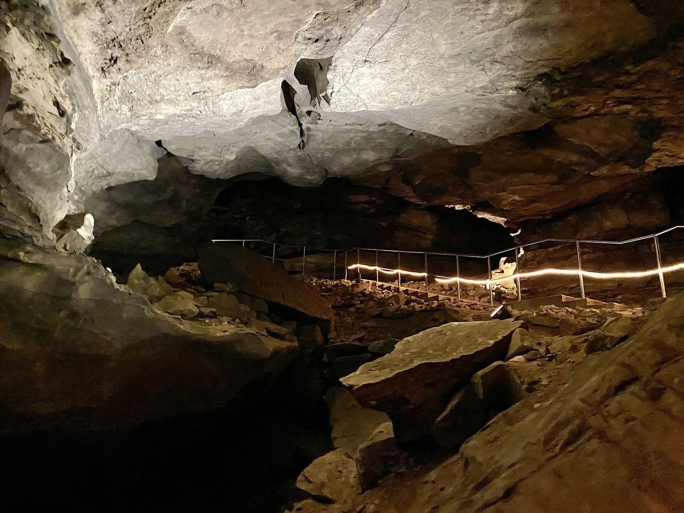 A lit boardwalk winding through the vast River Hall passage inside Mammoth Cave